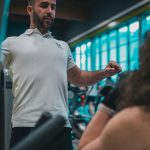 Sesión de entrenamiento en el gimnasio con un entrenador personal, enfocada en el rendimiento y el bienestar físico.