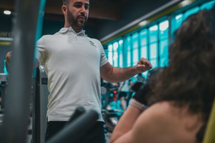 Sesión de entrenamiento en el gimnasio con un entrenador personal, enfocada en el rendimiento y el bienestar físico.